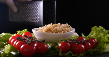 Beyaz eldiven bir şef bir deniz yemeği (salata) hazırlanan, karides parmesan peyniri sürtünme ve Çin çubukları kullanarak üstüne limon suyu sıkma ile süsler, sonra tatma. Kiraz domates arka plan.