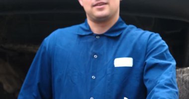 Sokakta neşeli bir araba tamircisi motor ve arabanın alt kısmını tamir, farklı duygular gösterir, büyük bir anahtarı ile dans eder. Kavramı: Hizmet, Joy, Yavaş hareket, Mood, Mutlu, Onarım.