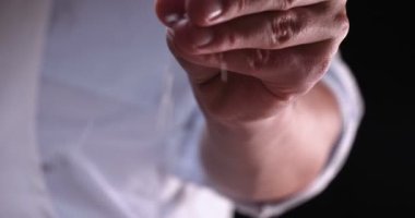 Siyah bir arka plan üzerinde yavaş çekimde, tuz (un) bir yandan strewed olduğunu. Konsept: Zaman, Mutfak, Yaşam, El, Kristal, Kristal Tuz.