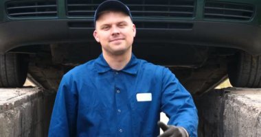 Sokakta neşeli bir araba tamircisi motor ve arabanın alt kısmını tamir, farklı duygular gösterir, büyük bir anahtarı ile dans eder. Kavramı: Hizmet, Joy, Yavaş hareket, Mood, Mutlu, Onarım.