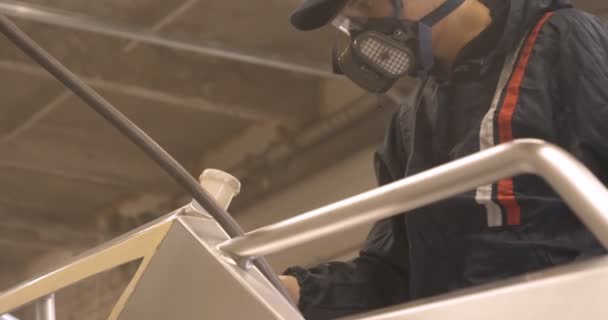 スローモーションで セーターを着た作業服のガレージ サービス でプロの男 塗装銃 スプレーガン を設定し セラミックスの層を入れて 塗装を開始しますヨット — ストック動画