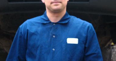 Sokakta neşeli bir araba tamircisi motor ve arabanın alt kısmını tamir, farklı duygular gösterir, büyük bir anahtarı ile dans eder. Kavramı: Hizmet, Joy, Yavaş hareket, Mood, Mutlu, Onarım.