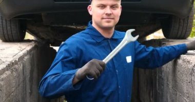 Sokakta neşeli bir araba tamircisi motor ve arabanın alt kısmını tamir, farklı duygular gösterir, büyük bir anahtarı ile dans eder. Kavramı: Hizmet, Joy, Yavaş hareket, Mood, Mutlu, Onarım.