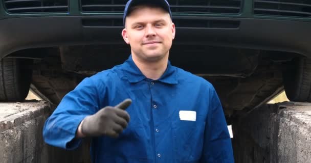 一个欢快的汽车修理工在街上修理发动机和汽车的下部 表现出不同的情感 用大扳手跳舞 慢动作 — 图库视频影像