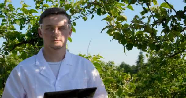 Genç Yakışıklı Erkek Biyolog Veya Agronomist Beyaz Bir Ceket Gözlük — Stok video