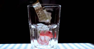 Barmen, bir parti için çeşitli içecekler (kokteyller) hazırlar. Disko veya evde barda meyve soğuk içecekler siyah arka planda görülür.