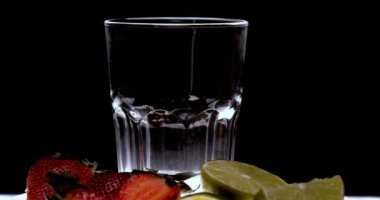 Barmen, bir parti için çeşitli içecekler (kokteyller) hazırlar. Disko veya evde barda meyve soğuk içecekler siyah arka planda görülür.