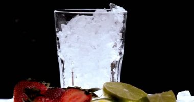 Barmen, bir parti için çeşitli içecekler (kokteyller) hazırlar. Disko veya evde barda meyve soğuk içecekler siyah arka planda görülür.