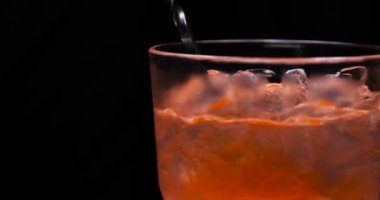Barmen, bir parti için çeşitli içecekler (kokteyller) hazırlar. Disko veya evde barda meyve soğuk içecekler siyah arka planda görülür.