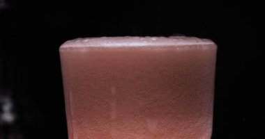 Barmen, bir parti için çeşitli içecekler (kokteyller) hazırlar. Disko veya evde barda meyve soğuk içecekler siyah arka planda görülür.