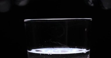 Barmen, bir parti için çeşitli içecekler (kokteyller) hazırlar. Disko veya evde barda meyve soğuk içecekler siyah arka planda görülür.