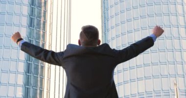 Genç bir adam (erkek) mimar, takım elbiseli bir işadamı, elinde tabletli bir klasör (cep telefonu) olan bir ceket içinde inşaat alanını ve iş binasını çeşitli eylemlerle kontrol ediyor..