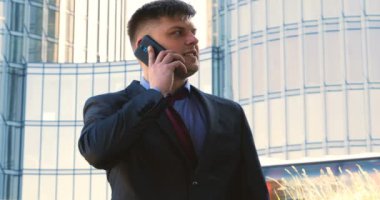 Genç bir adam (erkek) mimar, takım elbiseli bir işadamı, elinde tabletli bir klasör (cep telefonu) olan bir ceket içinde inşaat alanını ve iş binasını çeşitli eylemlerle kontrol ediyor..
