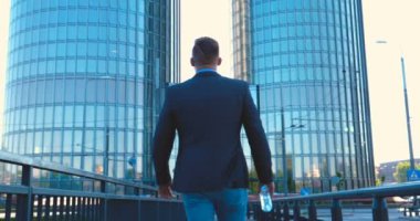 Genç bir adam (erkek) mimar, takım elbiseli bir işadamı, elinde tabletli bir klasör (cep telefonu) olan bir ceket içinde inşaat alanını ve iş binasını çeşitli eylemlerle kontrol ediyor..