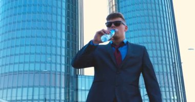 Genç bir adam (erkek) mimar, takım elbiseli bir işadamı, elinde tabletli bir klasör (cep telefonu) olan bir ceket içinde inşaat alanını ve iş binasını çeşitli eylemlerle kontrol ediyor..