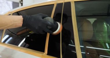 Profesyonel adam (adam) ile kulaklık ve çalışan bir üniforma parlatma aracı ile araba gövdesi parlatır. Konsept: Master Class, araba ferahlık, garaj Servisi, özel araçlar.