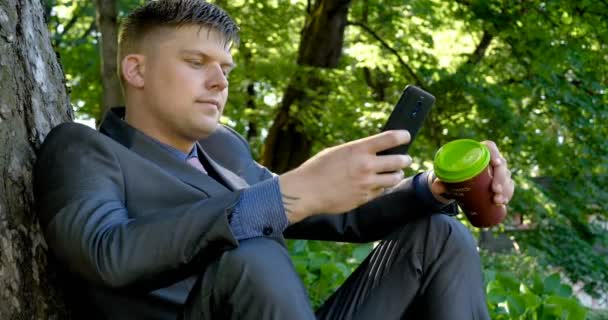 Junger Gutaussehender Typ Mann Geschäftsmann Der Sitzend Anzug Einem Baum — Stockvideo