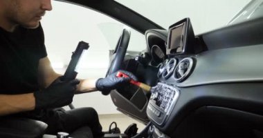 Genç adam (adam) farklı kimya ve farklı araçlar kullanarak, otomobil hizmetleri için hizmet bir çalışma üniforması içinde araba tam bir kuru temizleme yok. Konsept: Oto Oto Servisi, Oto Yıkama, Kuru Temizleme Makineleri.