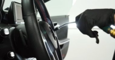 Genç adam (adam) farklı kimya ve farklı araçlar kullanarak, otomobil hizmetleri için hizmet bir çalışma üniforması içinde araba tam bir kuru temizleme yok. Konsept: Oto Oto Servisi, Oto Yıkama, Kuru Temizleme Makineleri.