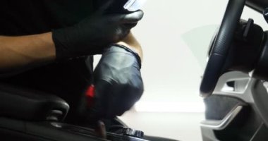 Genç adam (adam) farklı kimya ve farklı araçlar kullanarak, otomobil hizmetleri için hizmet bir çalışma üniforması içinde araba tam bir kuru temizleme yok. Konsept: Oto Oto Servisi, Oto Yıkama, Kuru Temizleme Makineleri.