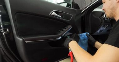 Genç adam (adam) farklı kimya ve farklı araçlar kullanarak, otomobil hizmetleri için hizmet bir çalışma üniforması içinde araba tam bir kuru temizleme yok. Konsept: Oto Oto Servisi, Oto Yıkama, Kuru Temizleme Makineleri.