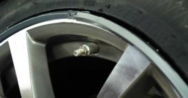 Profesyonel lastik değiştirici, çeşitli araçlar kullanarak araç sürücülerinde (lastik) korumayı değiştirir. Bir araba servisinde çalışan bir kriko üzerinde bir araba yükseltir (düşürür). Konsept: Oto oto yıkama, Araba Garajı, Araçlar, Bakım.