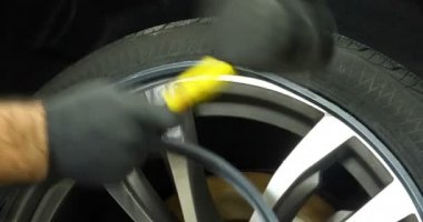 Profesyonel lastik değiştirici, çeşitli araçlar kullanarak araç sürücülerinde (lastik) korumayı değiştirir. Bir araba servisinde çalışan bir kriko üzerinde bir araba yükseltir (düşürür). Konsept: Oto oto yıkama, Araba Garajı, Araçlar, Bakım.