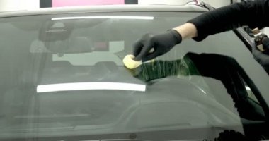 Profesyonel Oto Seramik İşçisi, araç camlarına bir seramik tabakası (koruyucu yağmur örtüsü) uygular. Konsept: Nano Koruma, Farklı aksesuarlar, Uzun koruma.