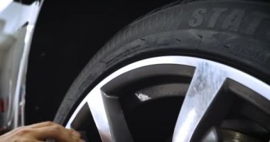 Profesyonel lastik değiştirici, çeşitli araçlar kullanarak araç sürücülerinde (lastik) korumayı değiştirir. Bir araba servisinde çalışan bir kriko üzerinde bir araba yükseltir (düşürür). Konsept: Oto oto yıkama, Araba Garajı, Araçlar, Bakım.