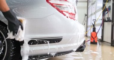 Profesyonel bir oto yıkama, bir araba yıkama ustası Karcher ve paçavra kullanarak tamamen beyaz bir bez yıkar. Yıkadıktan sonra, damlaların nasıl aktığını görebilirsiniz. Konsept: Balmumu, Seramik, Kimya.