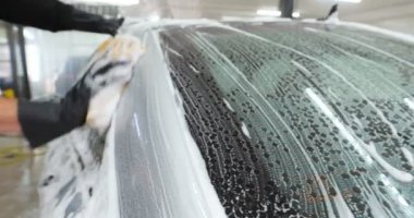 Profesyonel bir oto yıkama, bir araba yıkama ustası Karcher ve paçavra kullanarak tamamen beyaz bir bez yıkar. Yıkadıktan sonra, damlaların nasıl aktığını görebilirsiniz. Konsept: Balmumu, Seramik, Kimya.