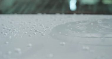 Profesyonel bir oto yıkama, bir araba yıkama ustası Karcher ve paçavra kullanarak tamamen beyaz bir bez yıkar. Yıkadıktan sonra, damlaların nasıl aktığını görebilirsiniz. Konsept: Balmumu, Seramik, Kimya.