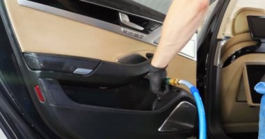 Yakışıklı genç adam, (adam) arabada profesyonel kuru temizleme salonu yapıyor. Konsept: Oto Oto Servisi, Oto Yıkama, Kuru Temizleme Makineleri.