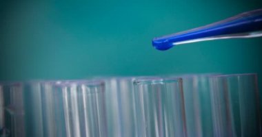 Simyacı, şişeler tutan, bir testin farklı kompozisyonlar, beyaz önlük, solunum, Gözlük, beyaz eldivenleri, yeşil bir arka plan ile test tüpleri testleri.
