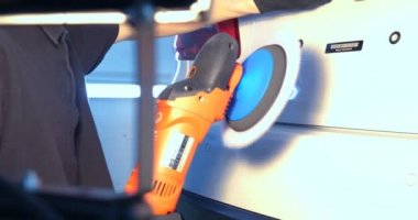 Profesyonel adam (adam) ile kulaklık ve çalışan bir üniforma parlatma aracı ile araba gövdesi parlatır. Konsept: Master Class, araba ferahlık, garaj Servisi, özel araçlar.