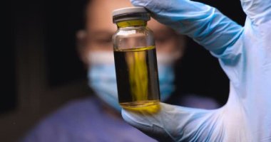 Laboratuar işçisi bilim adamı laboratuar asistanı test tüplerinde reaksiyonlar için kimyasalları testler, farklı maddelere müdahale ve görsel bir reaksiyon elde etmek. Erkek doktor iş üniforma giyen eldiven ile gözlük gözlük inceliyor içinde vitro.