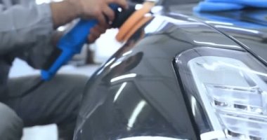 Çalışan siyah bir araba parlatır bir profesyonel, tamir araba, çocuk arabaları, oto yıkama, servis, Profesyonel Araba Seramik İşçi araba camları seramik (koruyucu yağmur kapağı) bir tabaka uygular. Konsept: Nano Koruma, Farklı acces