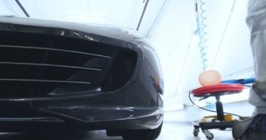 Çalışan siyah bir araba parlatır bir profesyonel, tamir araba, çocuk arabaları, oto yıkama, servis, Profesyonel Araba Seramik İşçi araba camları seramik (koruyucu yağmur kapağı) bir tabaka uygular. Konsept: Nano Koruma, Farklı acces