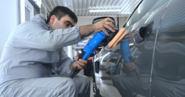 Çalışan siyah bir araba parlatır bir profesyonel, tamir araba, çocuk arabaları, oto yıkama, servis, Profesyonel Araba Seramik İşçi araba camları seramik (koruyucu yağmur kapağı) bir tabaka uygular. Konsept: Nano Koruma, Farklı acces