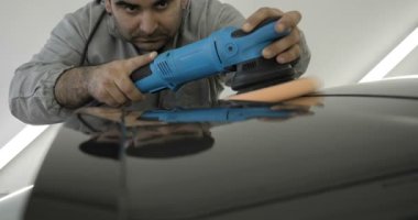Çalışan siyah bir araba parlatır bir profesyonel, tamir araba, çocuk arabaları, oto yıkama, servis, Profesyonel Araba Seramik İşçi araba camları seramik (koruyucu yağmur kapağı) bir tabaka uygular. Konsept: Nano Koruma, Farklı acces