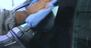 Çalışan siyah bir araba parlatır bir profesyonel, tamir araba, çocuk arabaları, oto yıkama, servis, Profesyonel Araba Seramik İşçi araba camları seramik (koruyucu yağmur kapağı) bir tabaka uygular. Konsept: Nano Koruma, Farklı acces