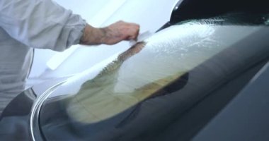 Çalışan siyah bir araba parlatır bir profesyonel, tamir araba, çocuk arabaları, oto yıkama, servis, Profesyonel Araba Seramik İşçi araba camları seramik (koruyucu yağmur kapağı) bir tabaka uygular. Konsept: Nano Koruma, Farklı acces