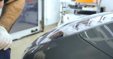 Çalışan siyah bir araba parlatır bir profesyonel, tamir araba, çocuk arabaları, oto yıkama, servis, Profesyonel Araba Seramik İşçi araba camları seramik (koruyucu yağmur kapağı) bir tabaka uygular. Konsept: Nano Koruma, Farklı acces