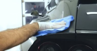 Çalışan siyah bir araba parlatır bir profesyonel, tamir araba, çocuk arabaları, oto yıkama, servis, Profesyonel Araba Seramik İşçi araba camları seramik (koruyucu yağmur kapağı) bir tabaka uygular. Konsept: Nano Koruma, Farklı acces