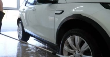 Çalışan siyah bir araba parlatır bir profesyonel, tamir araba, çocuk arabaları, oto yıkama, servis, Profesyonel Araba Seramik İşçi araba camları seramik (koruyucu yağmur kapağı) bir tabaka uygular. Konsept: Nano Koruma, Farklı acces