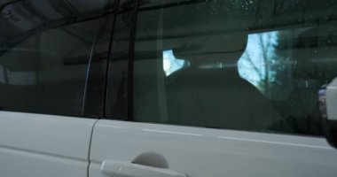 Çalışan siyah bir araba parlatır bir profesyonel, tamir araba, çocuk arabaları, oto yıkama, servis, Profesyonel Araba Seramik İşçi araba camları seramik (koruyucu yağmur kapağı) bir tabaka uygular. Konsept: Nano Koruma, Farklı acces