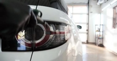 Çalışan siyah bir araba parlatır bir profesyonel, tamir araba, çocuk arabaları, oto yıkama, servis, Profesyonel Araba Seramik İşçi araba camları seramik (koruyucu yağmur kapağı) bir tabaka uygular. Konsept: Nano Koruma, Farklı acces