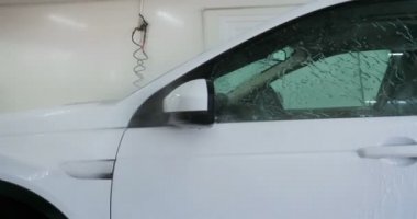 Çalışan siyah bir araba parlatır bir profesyonel, tamir araba, çocuk arabaları, oto yıkama, servis, Profesyonel Araba Seramik İşçi araba camları seramik (koruyucu yağmur kapağı) bir tabaka uygular. Konsept: Nano Koruma, Farklı acces