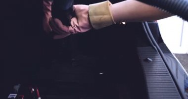 Çalışan siyah bir araba parlatır bir profesyonel, tamir araba, çocuk arabaları, oto yıkama, servis, Profesyonel Araba Seramik İşçi araba camları seramik (koruyucu yağmur kapağı) bir tabaka uygular. Konsept: Nano Koruma, Farklı acces