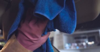 Çalışan siyah bir araba parlatır bir profesyonel, tamir araba, çocuk arabaları, oto yıkama, servis, Profesyonel Araba Seramik İşçi araba camları seramik (koruyucu yağmur kapağı) bir tabaka uygular. Konsept: Nano Koruma, Farklı acces